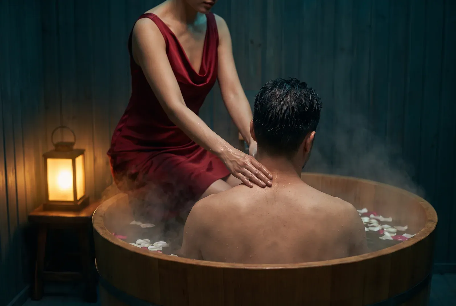 Massagem nos ombros durante a imersão no ofurô, com pétalas e vapor